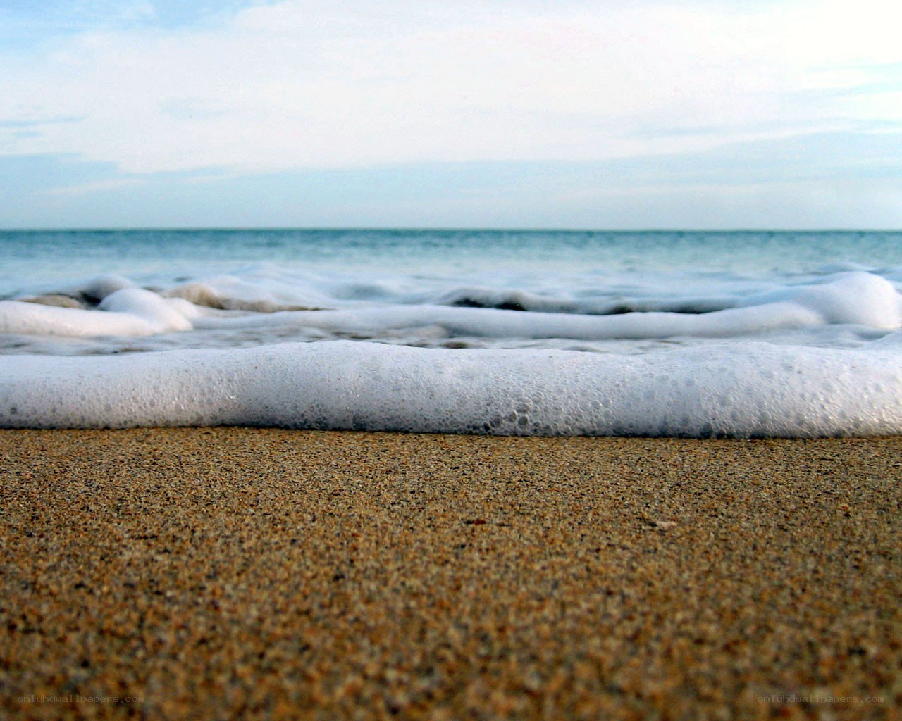 foamy waves on sandy beach