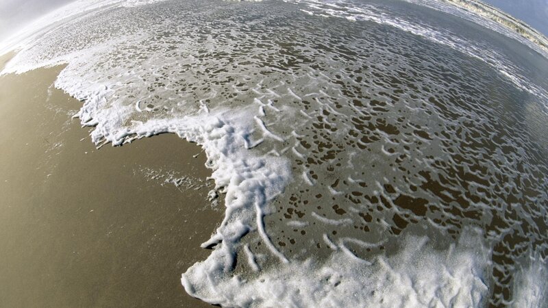 Foamy waves on sandy beach