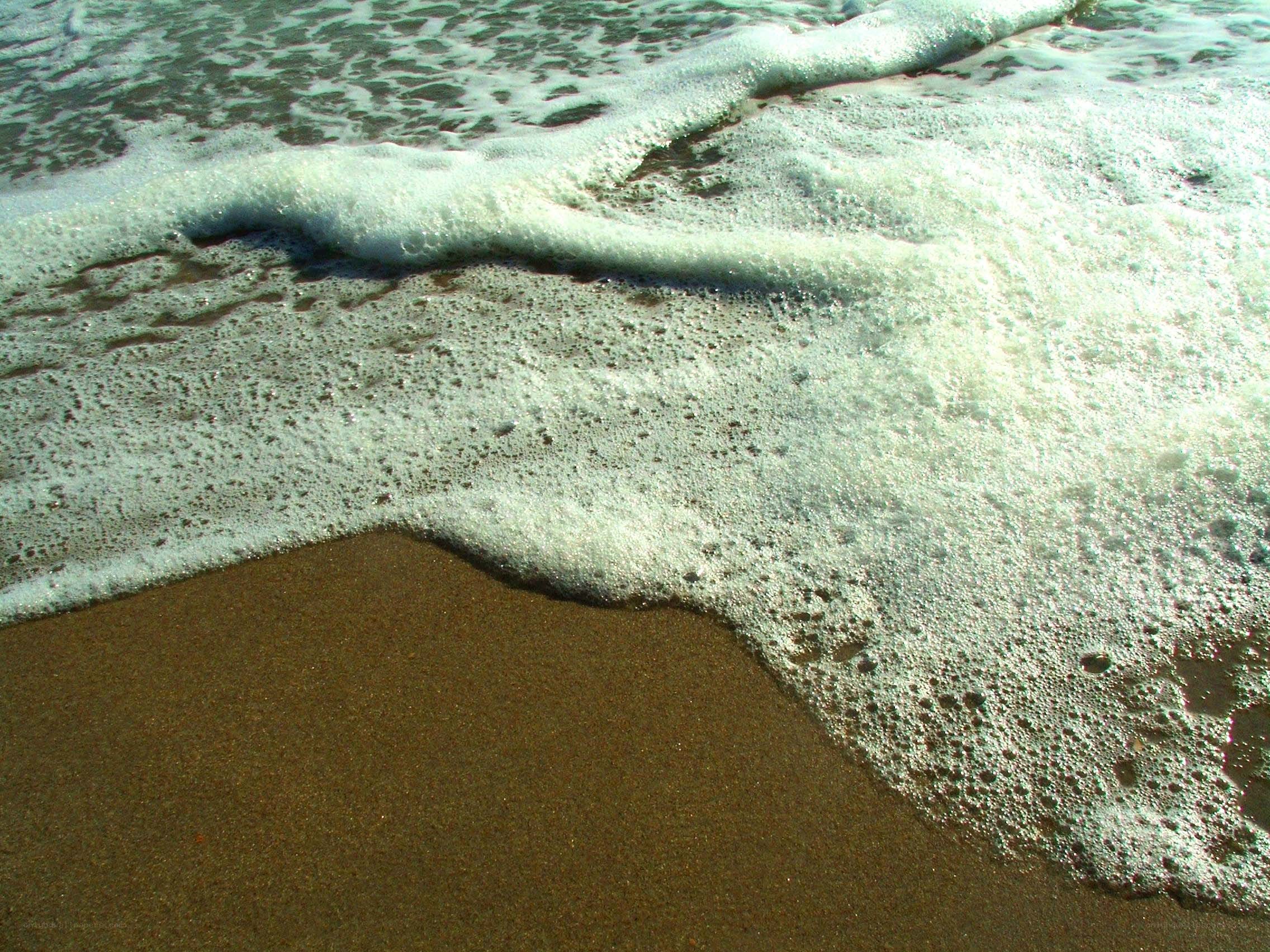 foamy waves on sandy beach