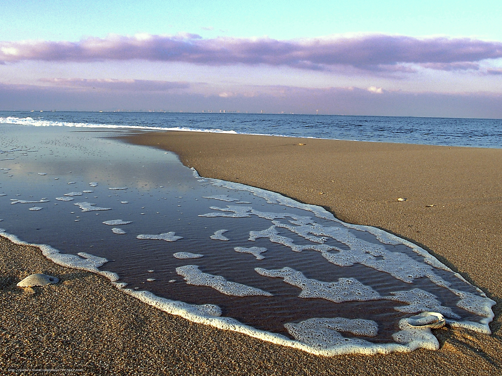 foamy waves on sandy beach