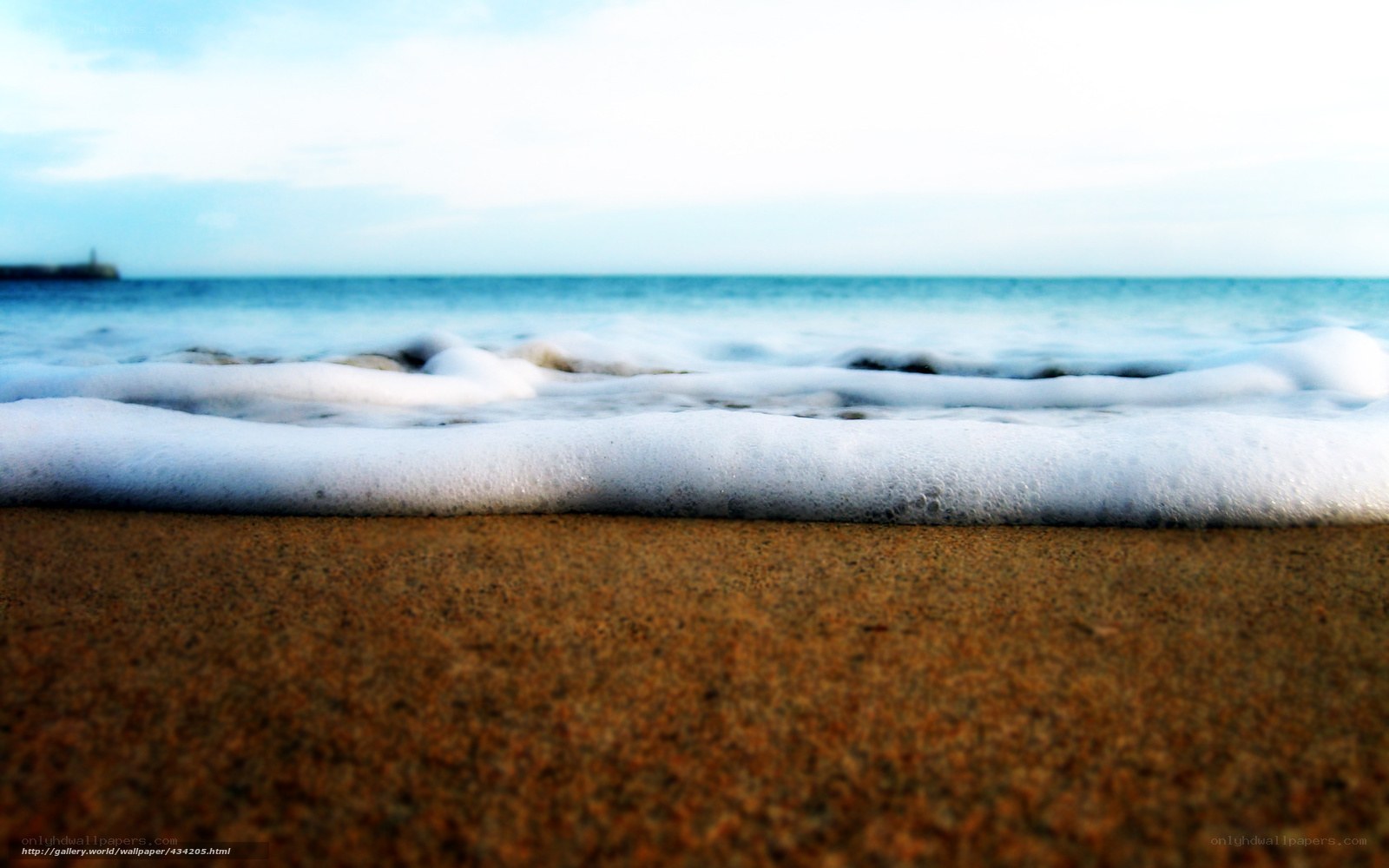 Foamy waves on sandy beach