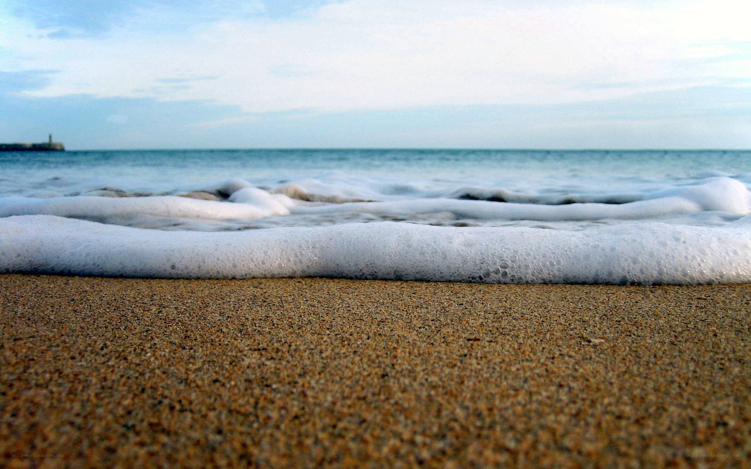 Foamy waves on sandy beach