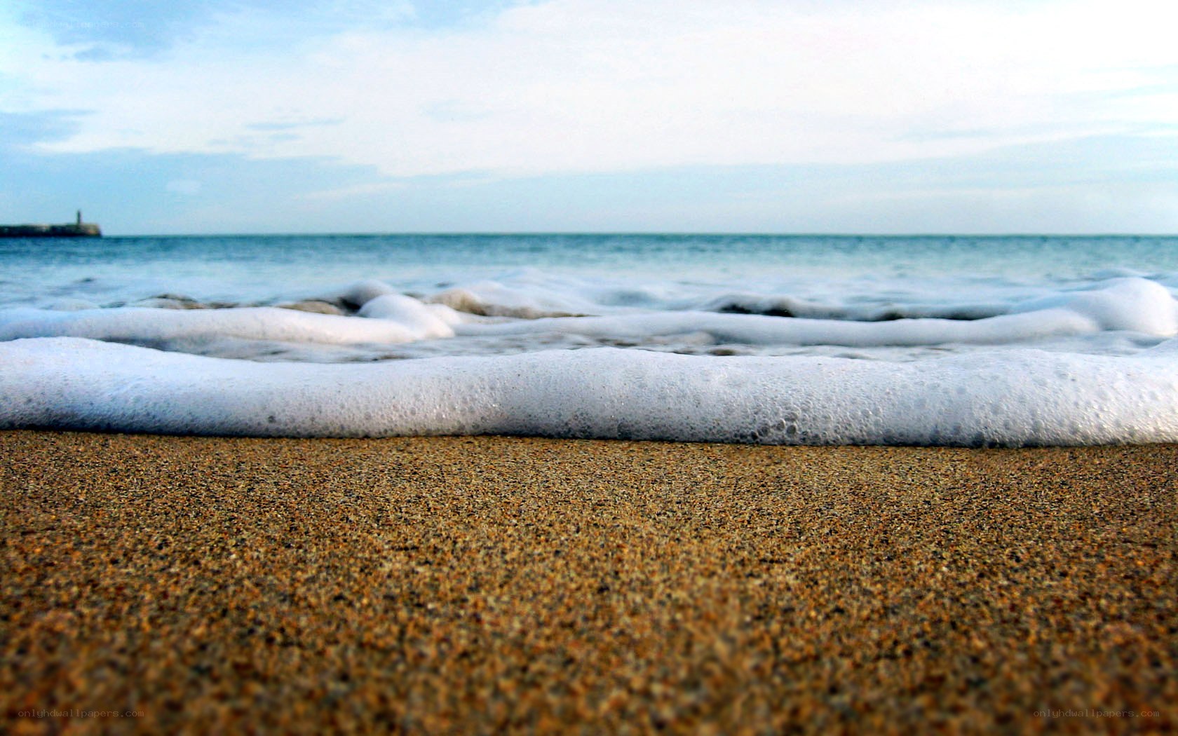 foamy waves on sandy beach