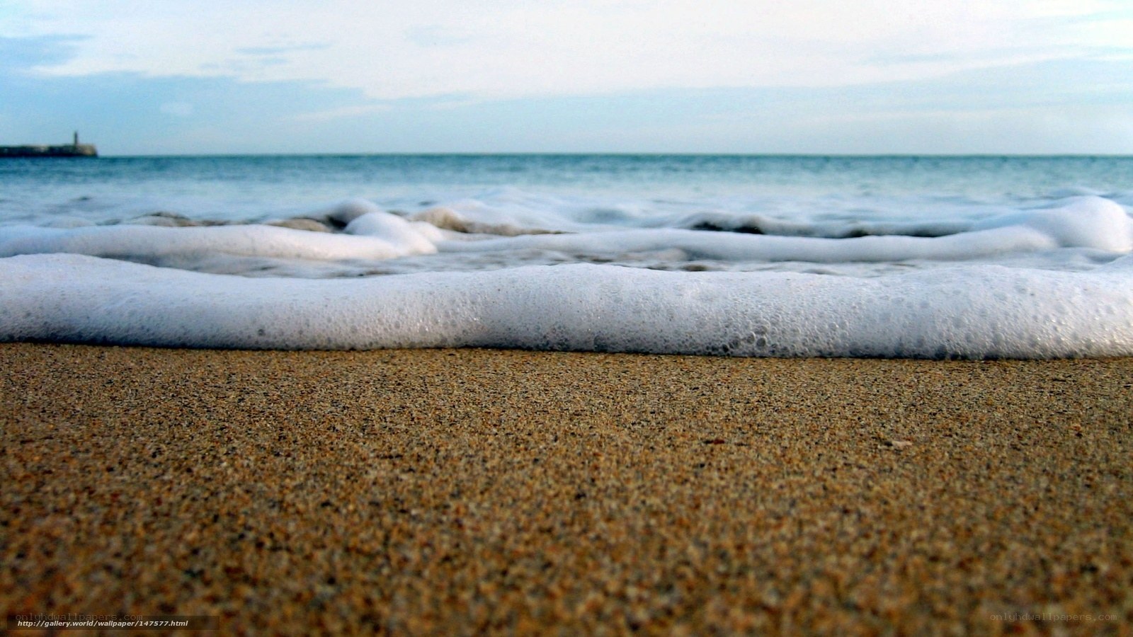 foamy waves on sandy beach