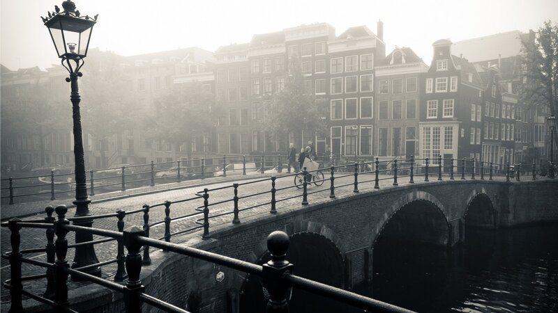 foggy canal bridge in amsterdam