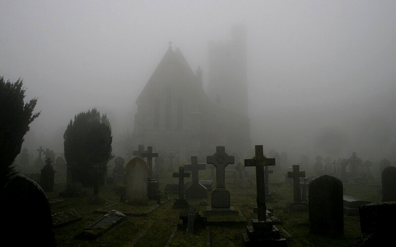 Foggy cemetery with church