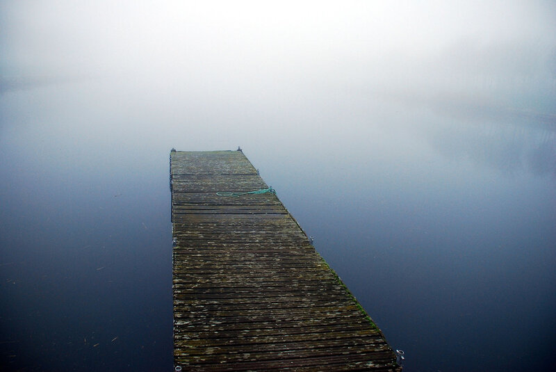 Foggy dock on calm water