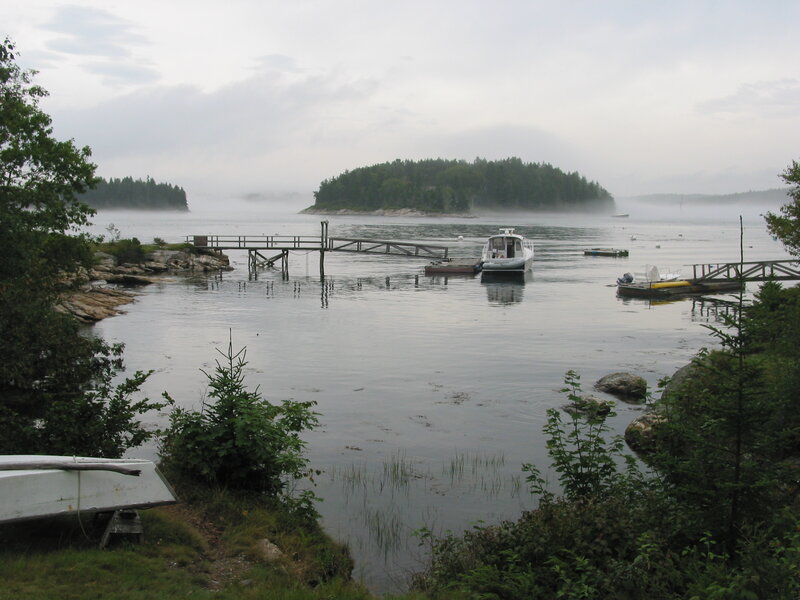 Foggy harbor with boats and islands