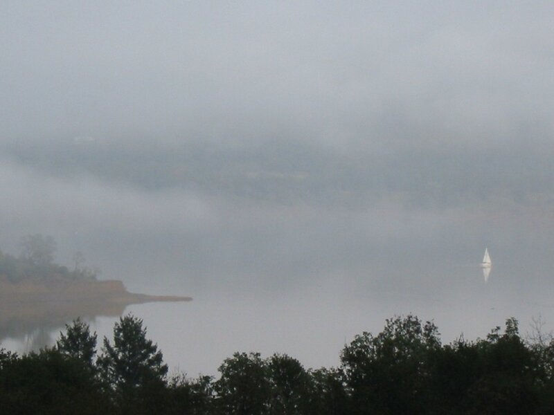 foggy lake with sailboat