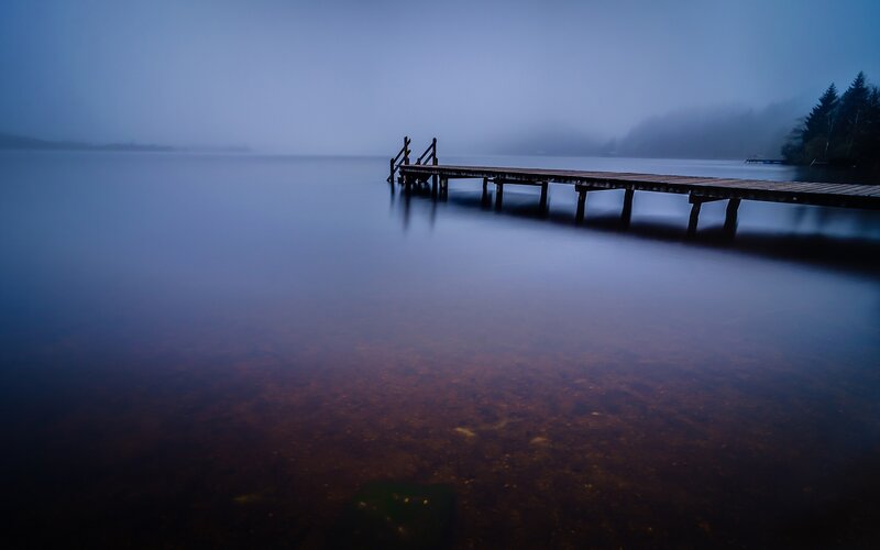 Foggy lake with wooden pier