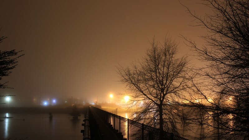 Foggy night over a flooded walkway