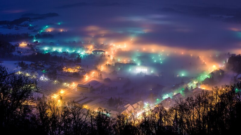 Foggy night over a snow-covered village