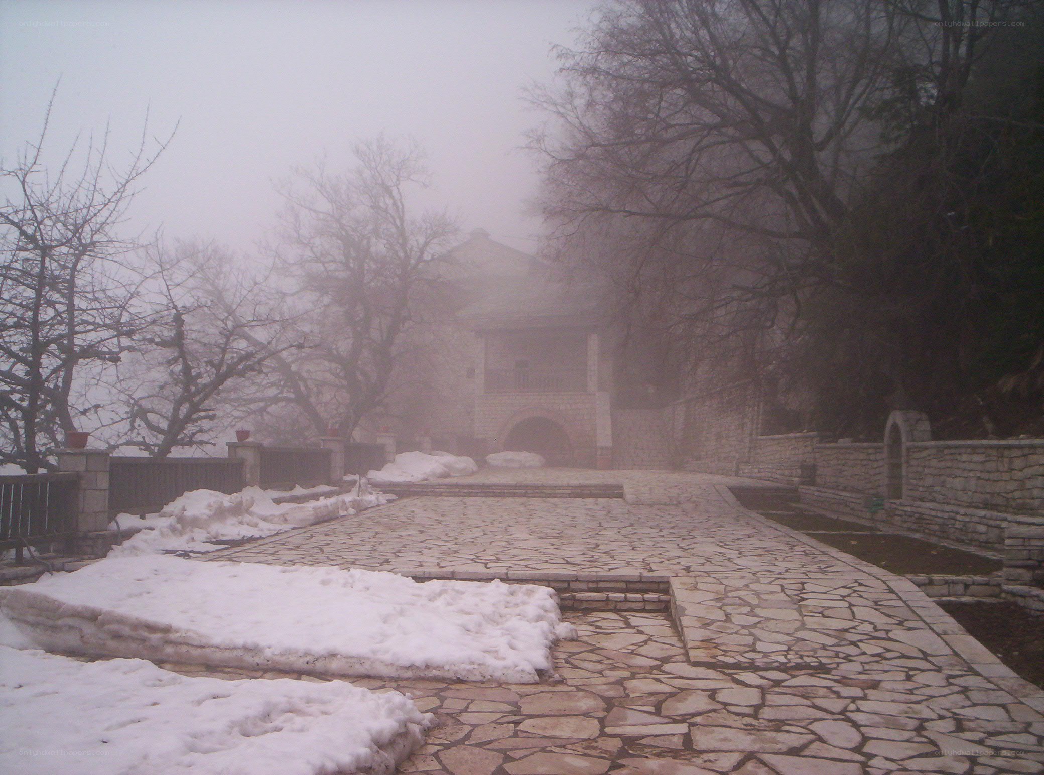 Foggy path to stone building