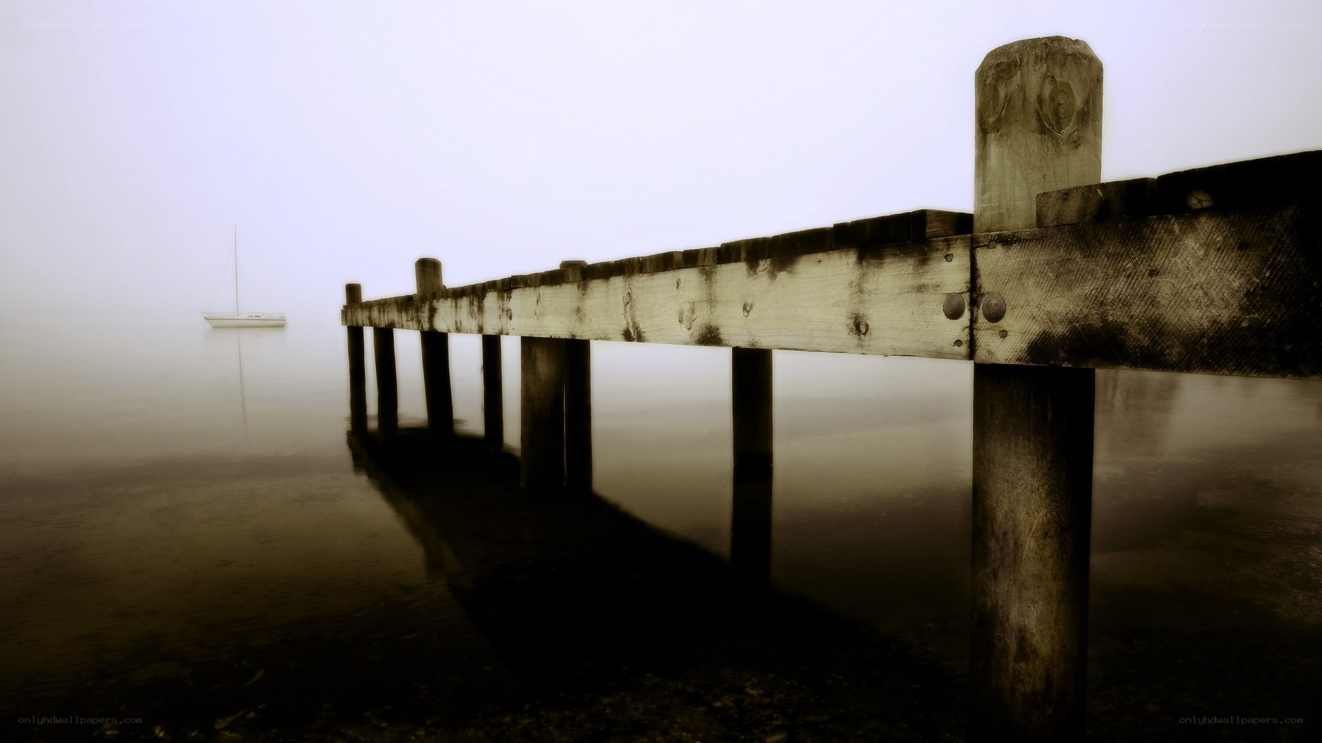 Foggy pier with sailboat