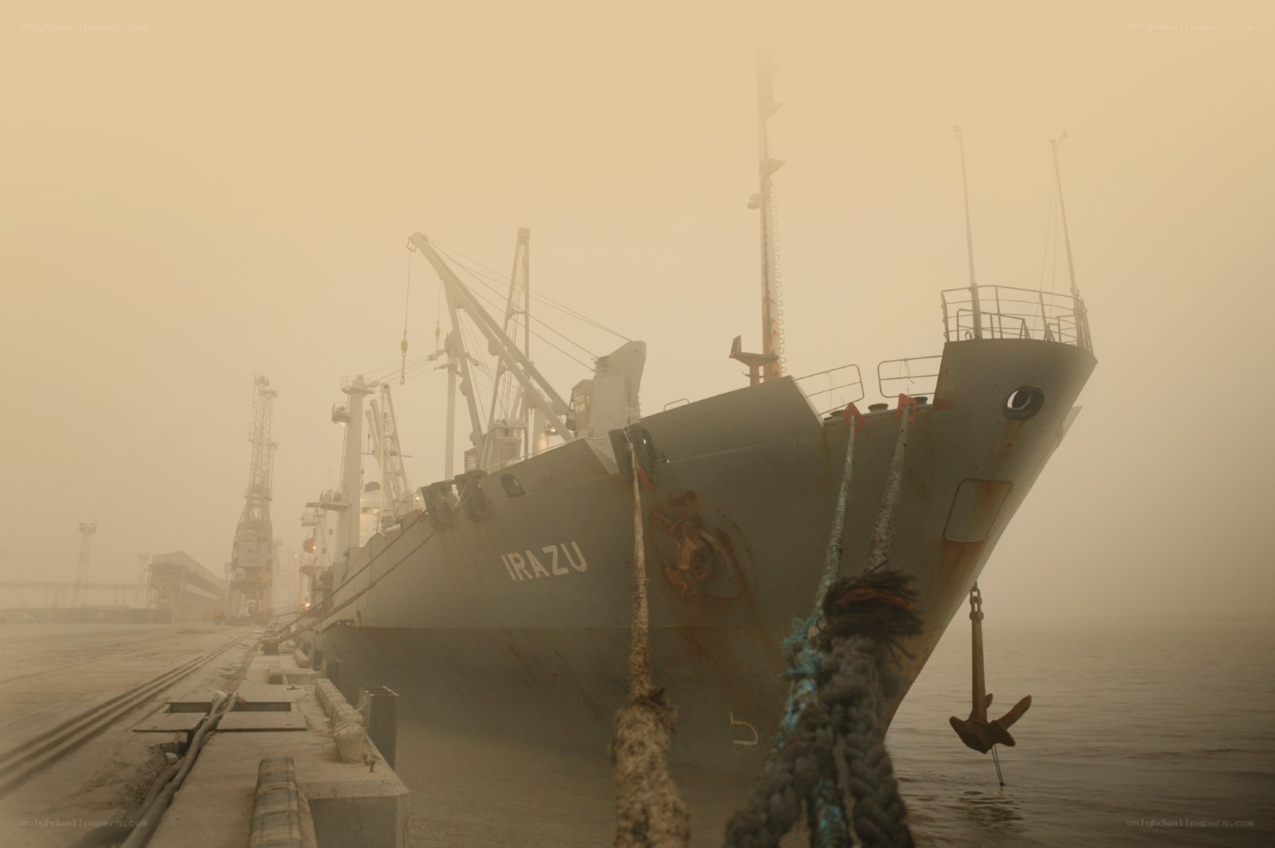 Foggy port with cargo ship