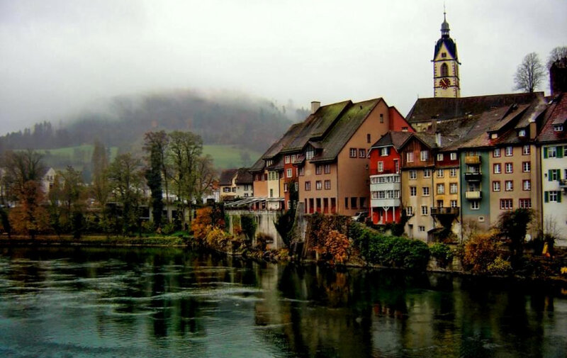 foggy riverside town in switzerland