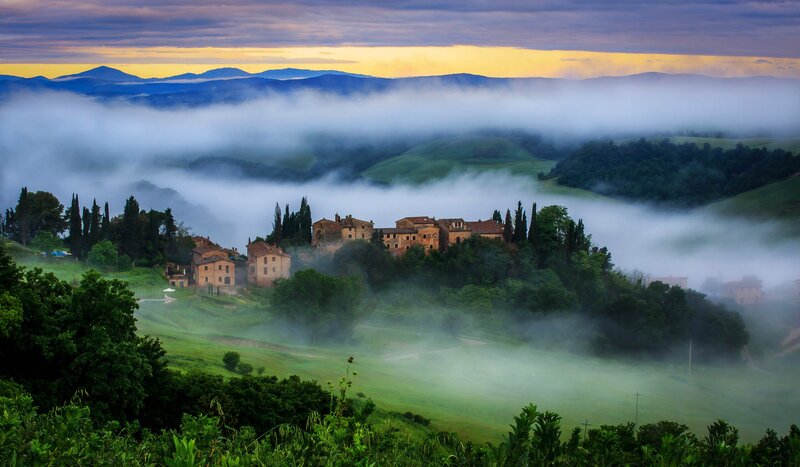 Foggy Tuscan village at dawn