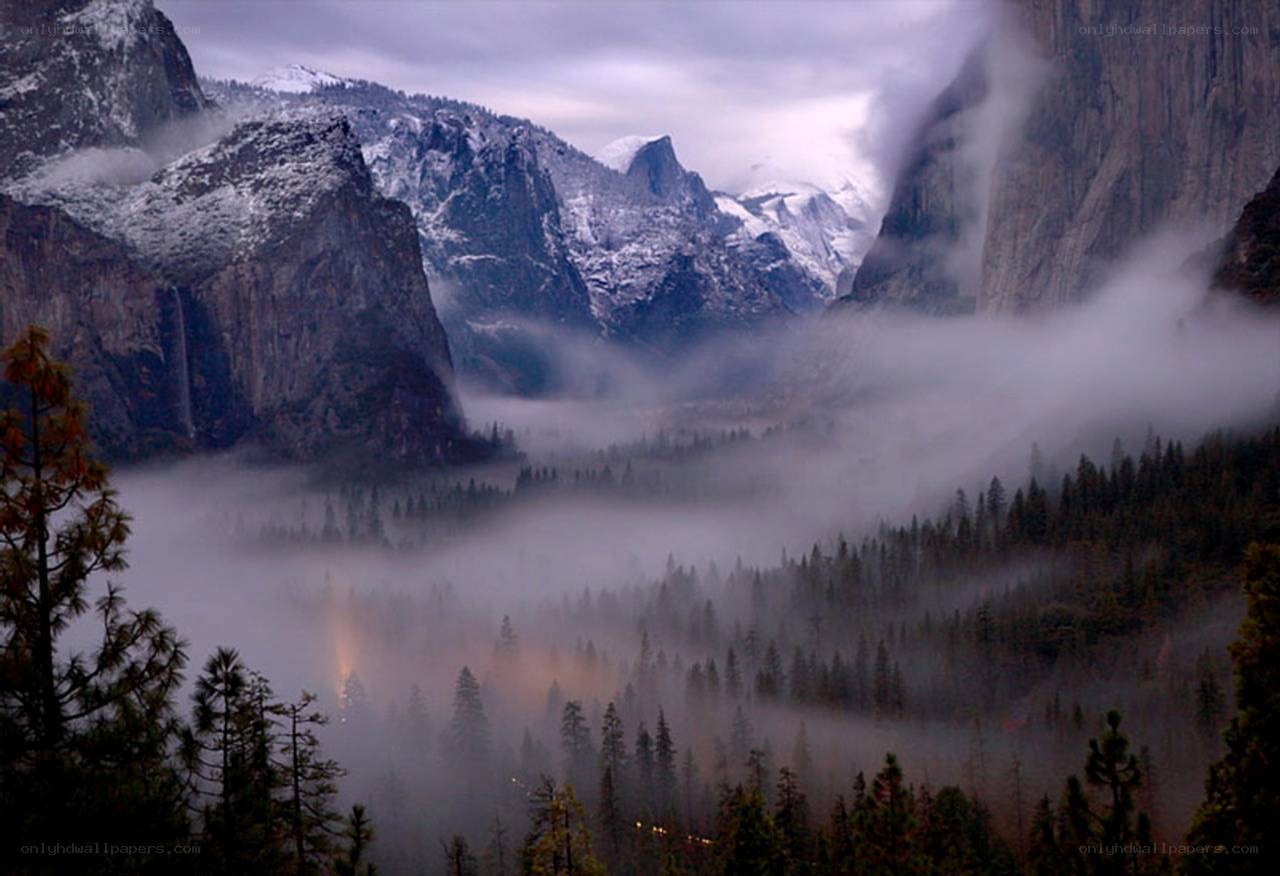 foggy valley with snow-capped mountains