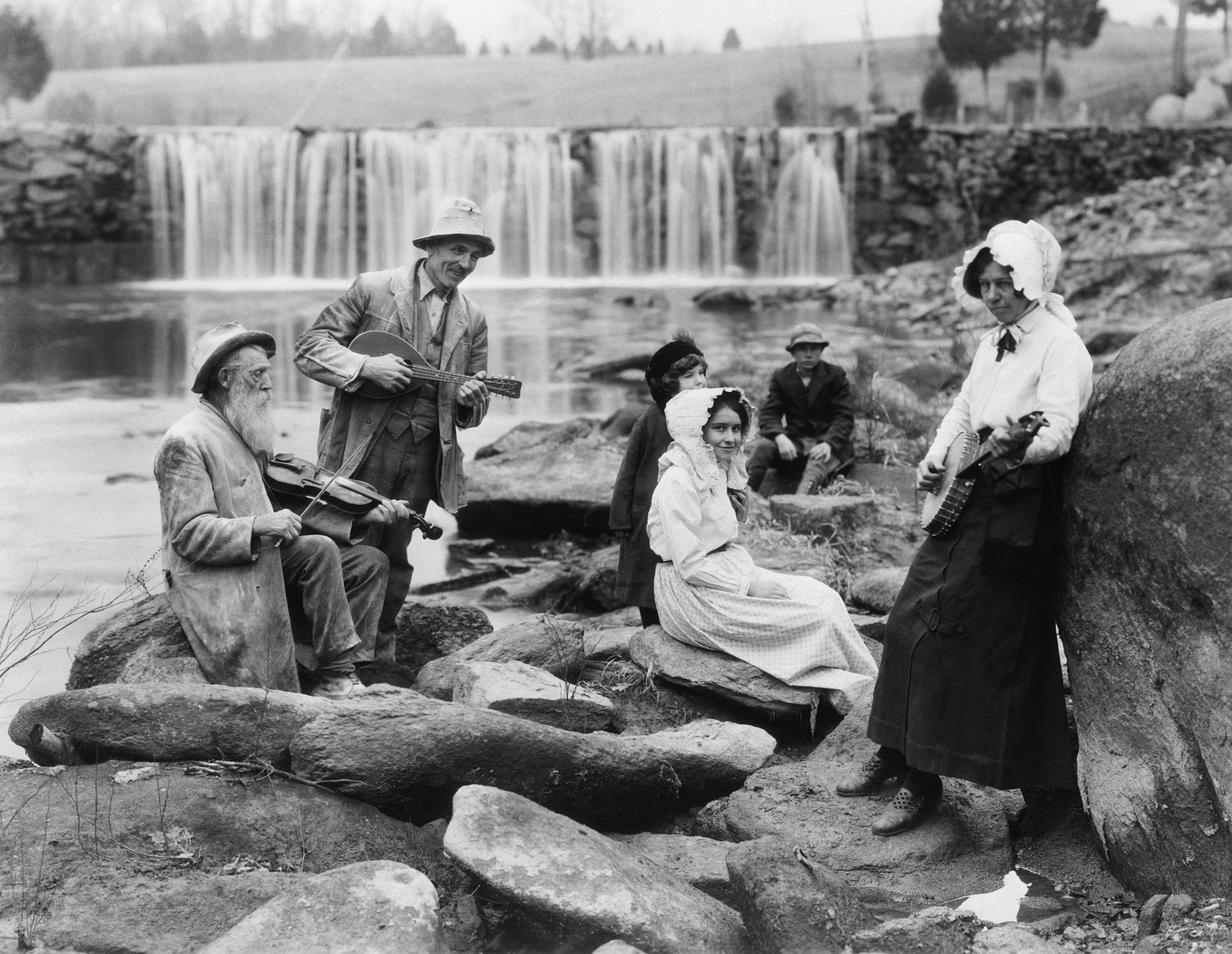 Folk musicians by a waterfall