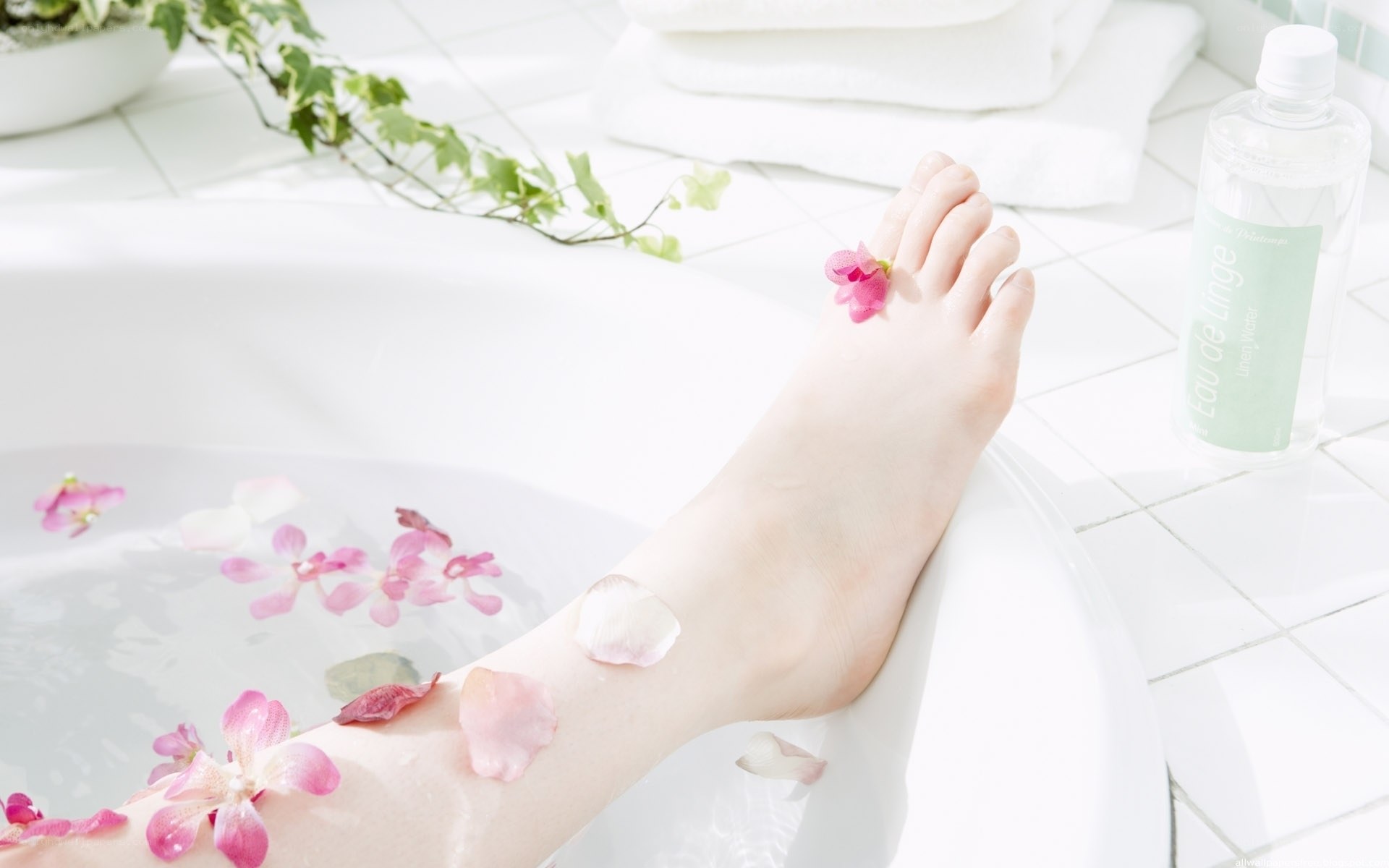 Foot in bathtub with flowers