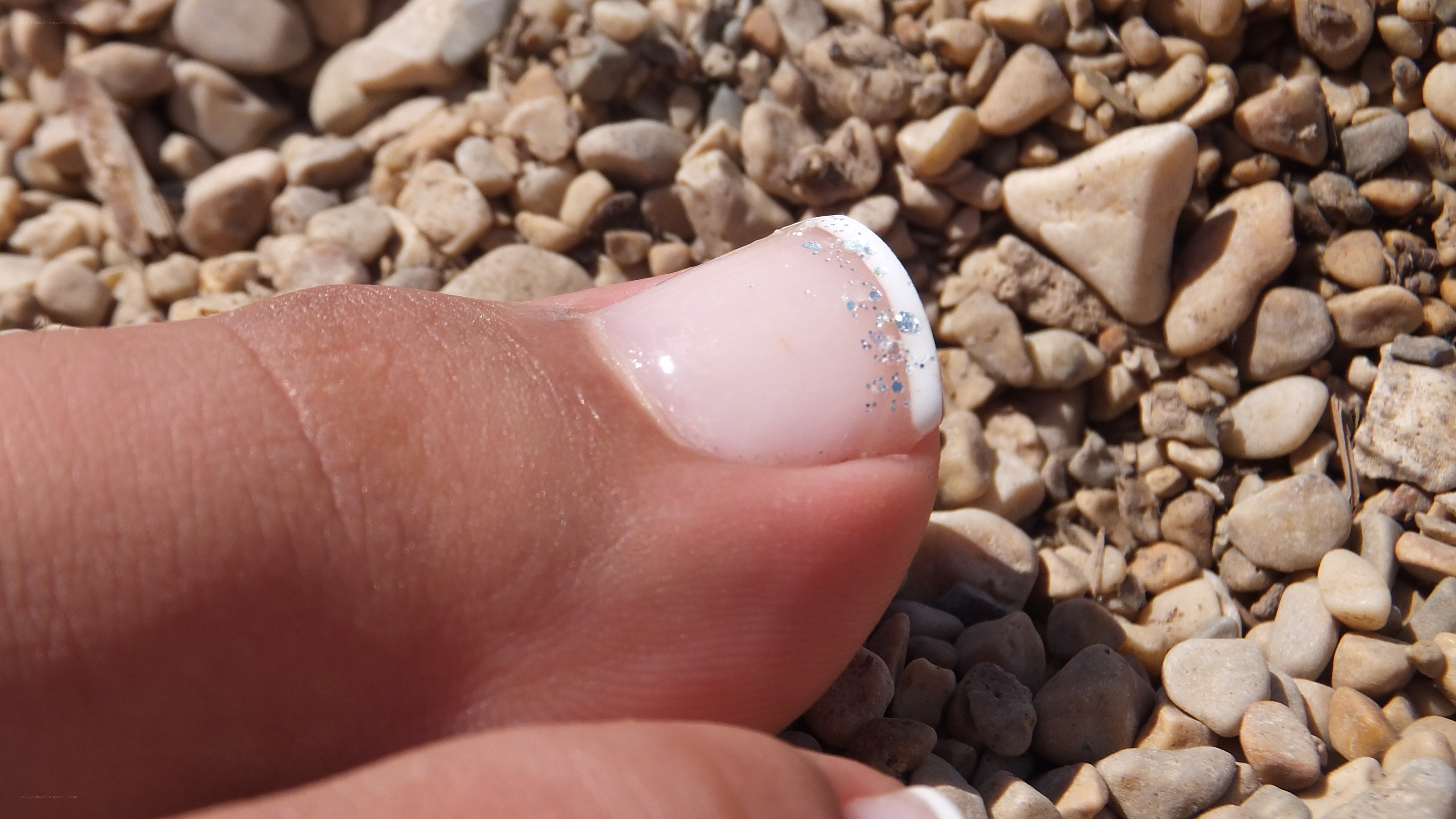 foot with nail polish on pebbles