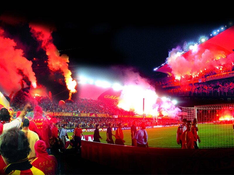 Football fans with flares at night