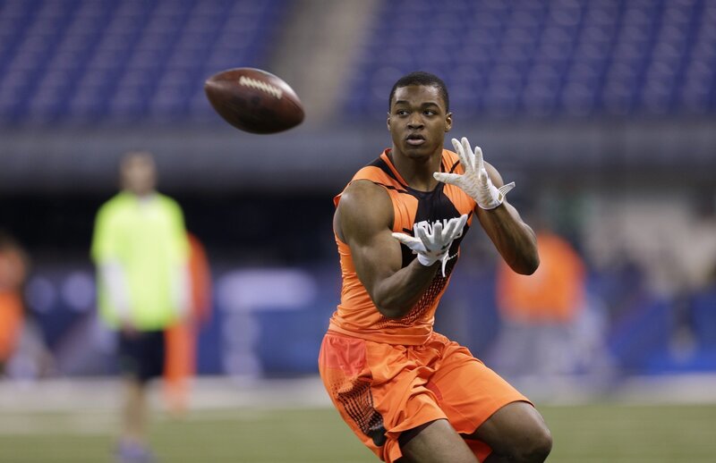 Football Player Catching Ball — Orange, Focused