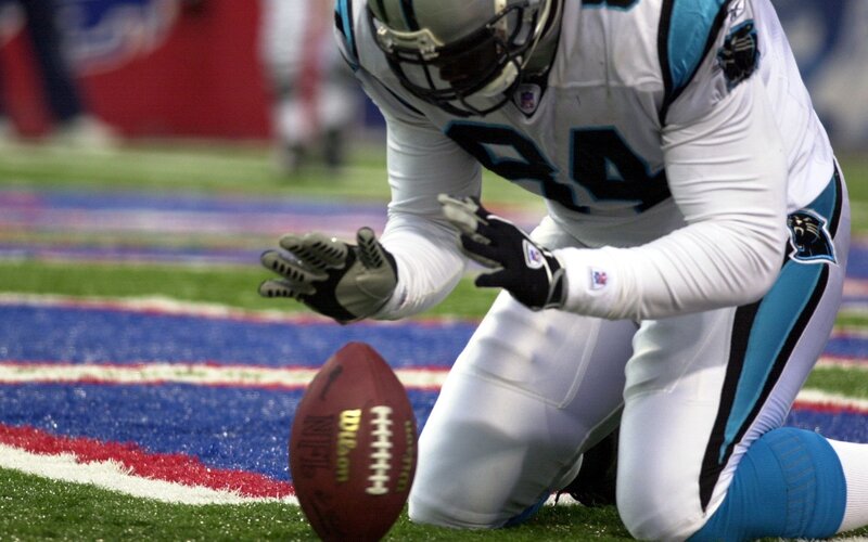 football player kneeling on field