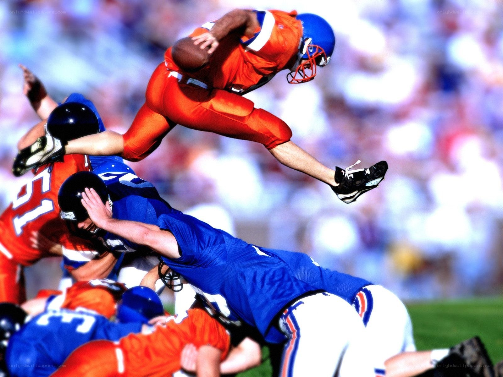 Football player leaps over tackle