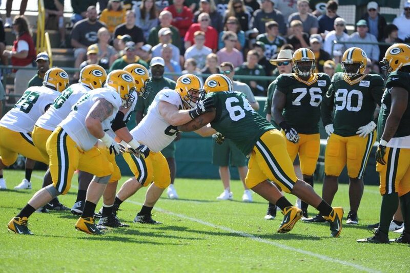 Football Players in Action — Green, Competitive, Afternoon