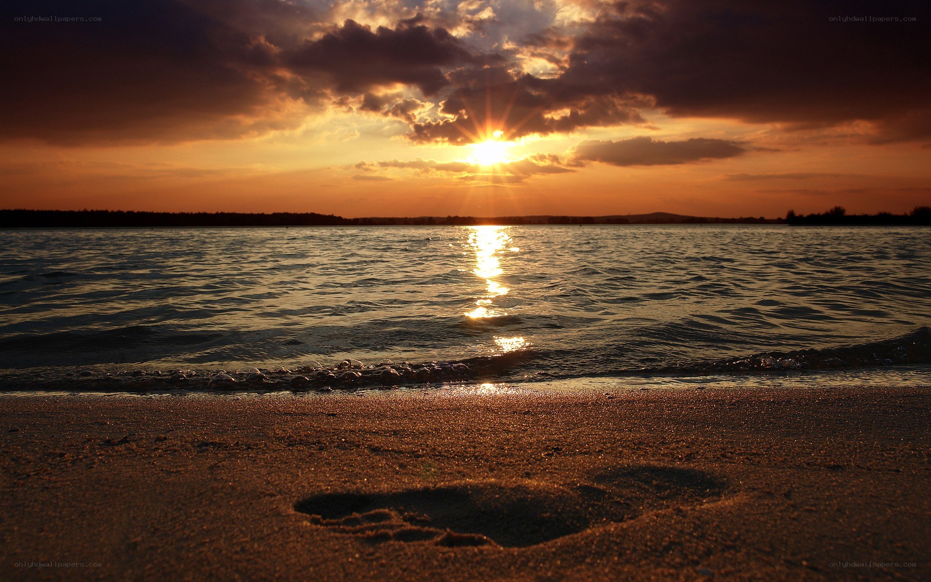 Footprint on beach at sunset