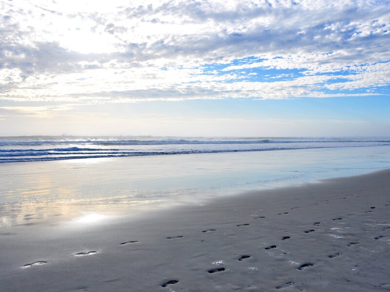Footprints on a beach at sunrise