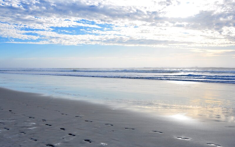 Footprints on a beach at sunrise