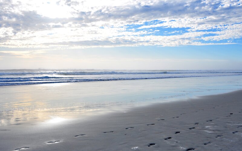 Footprints on a beach at sunrise