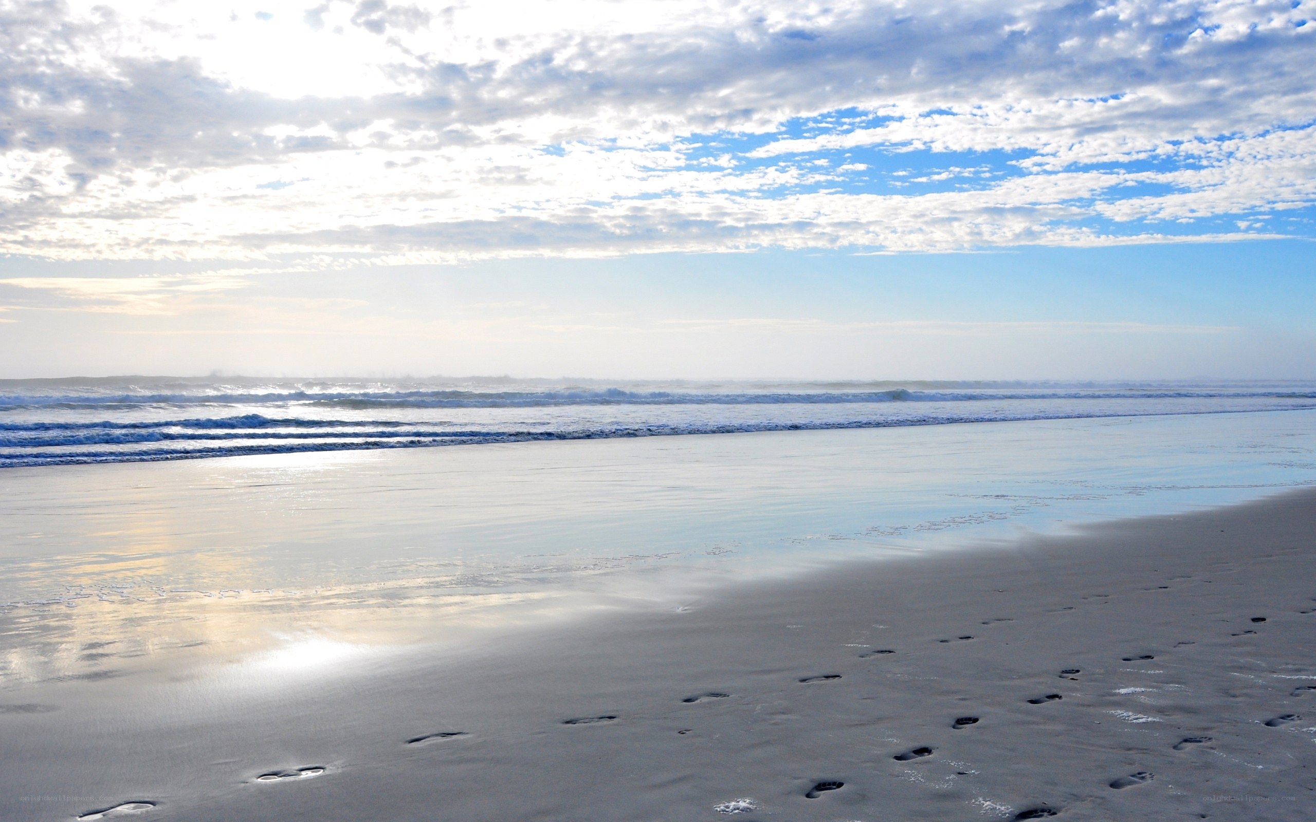 Footprints on a beach at sunrise