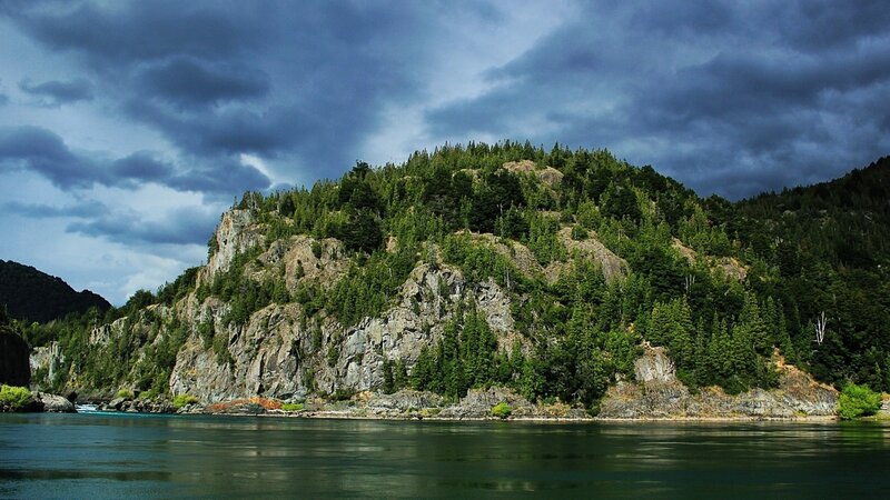Forest-covered cliff by a river