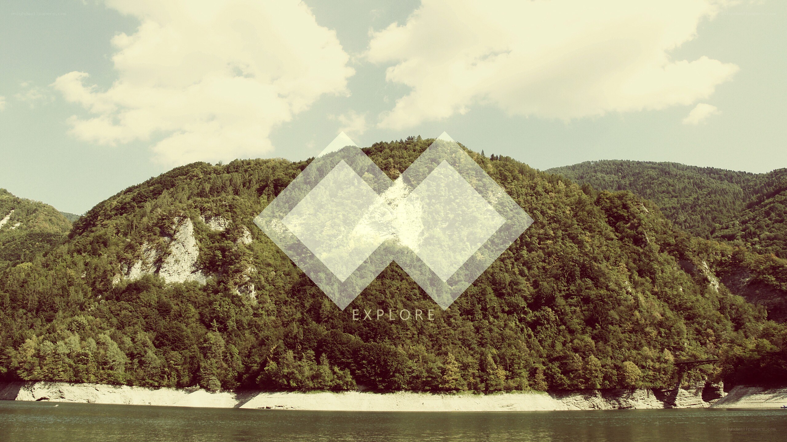 forest-covered hills by a lake