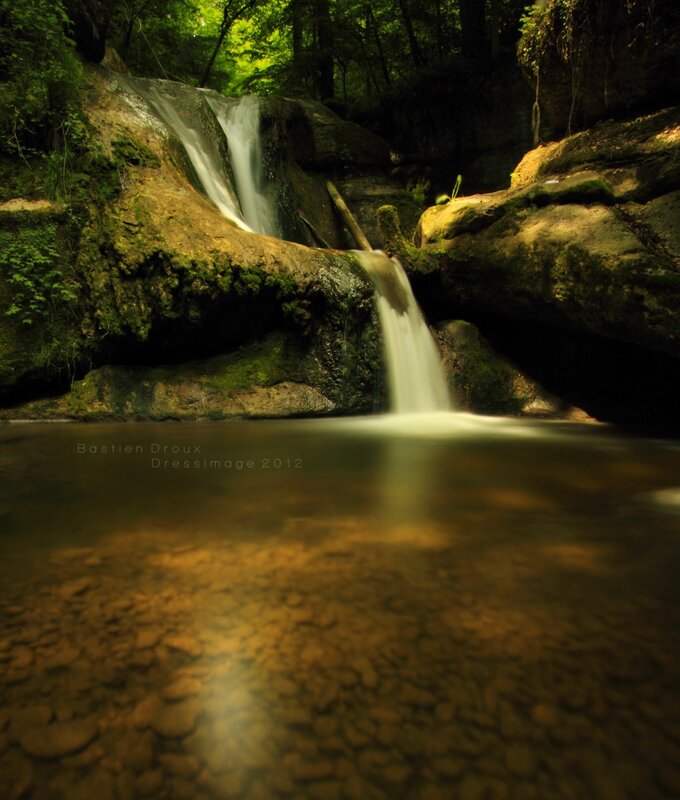 Forest waterfall in sunlight