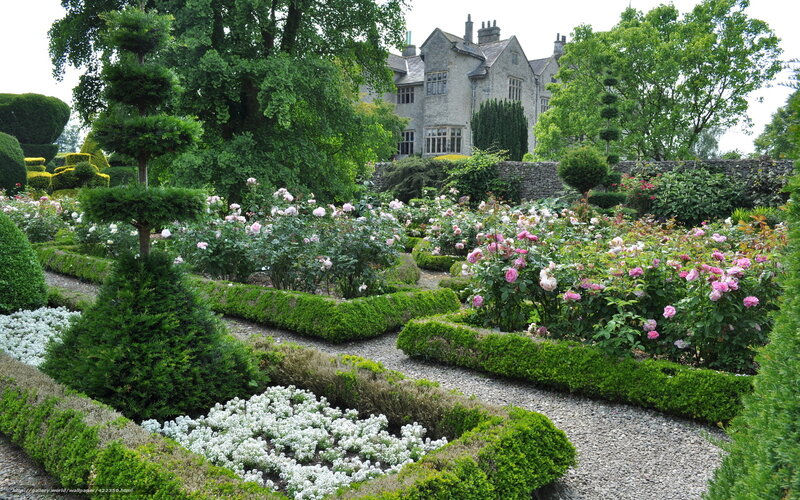 formal garden with roses and stone house
