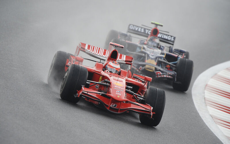 Formula 1 cars racing on a wet track