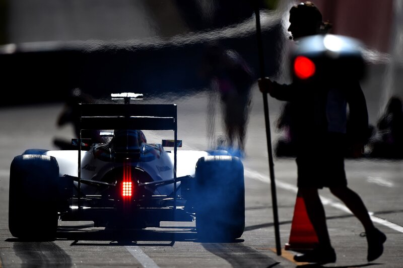 Formula One Car on Track — Black, Dramatic, Afternoon, Photograph, Person with Flag