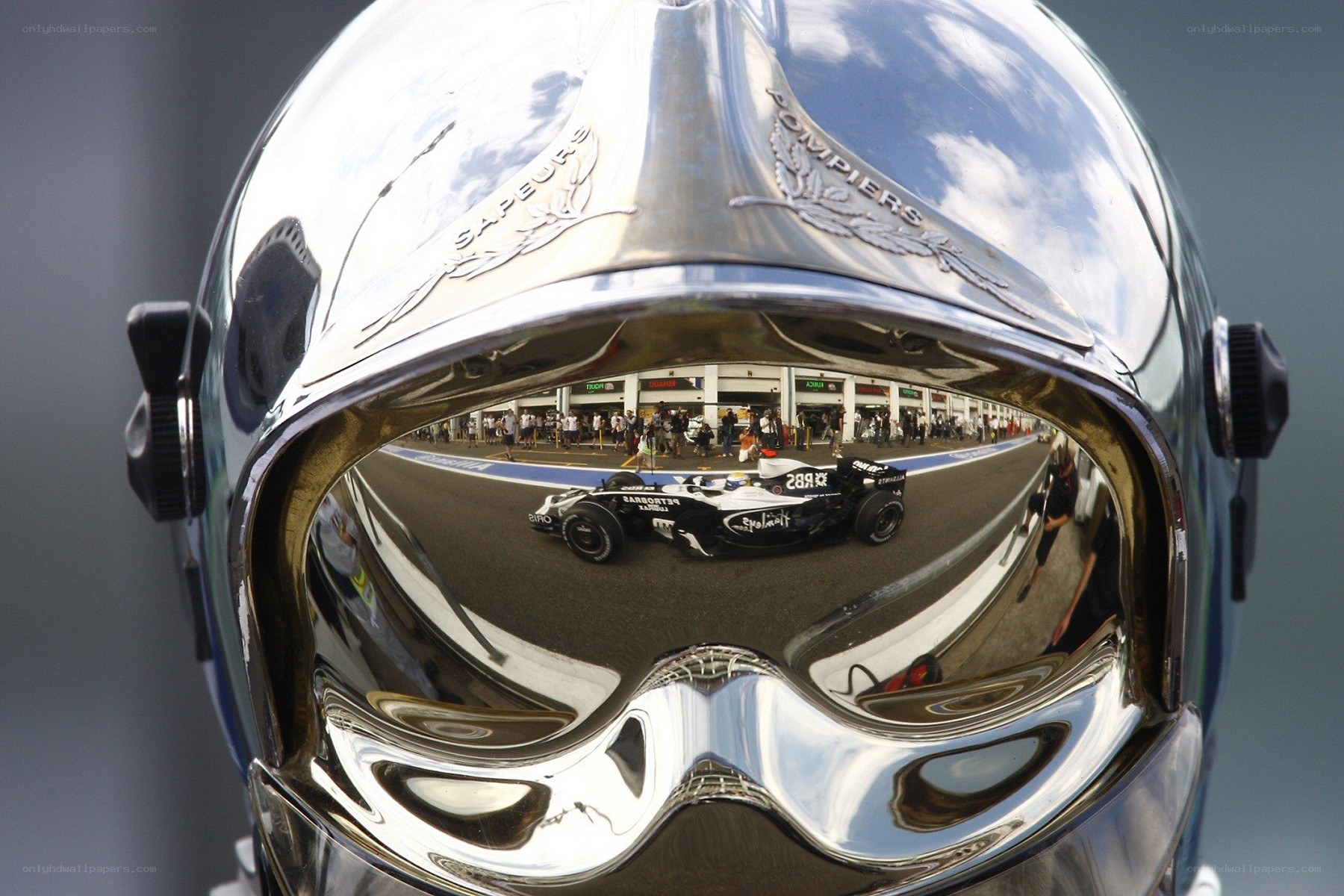 Formula One car reflected in a helmet