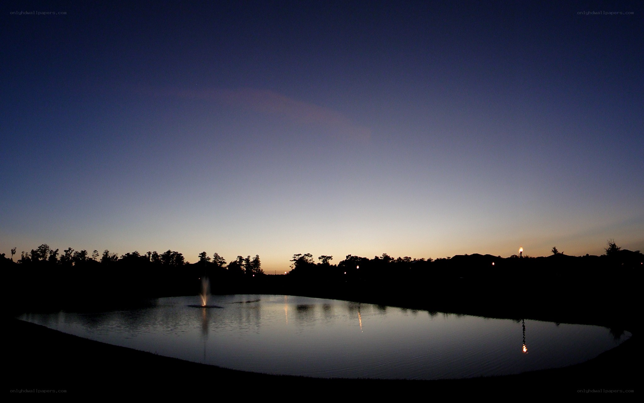fountain at dusk by the pond