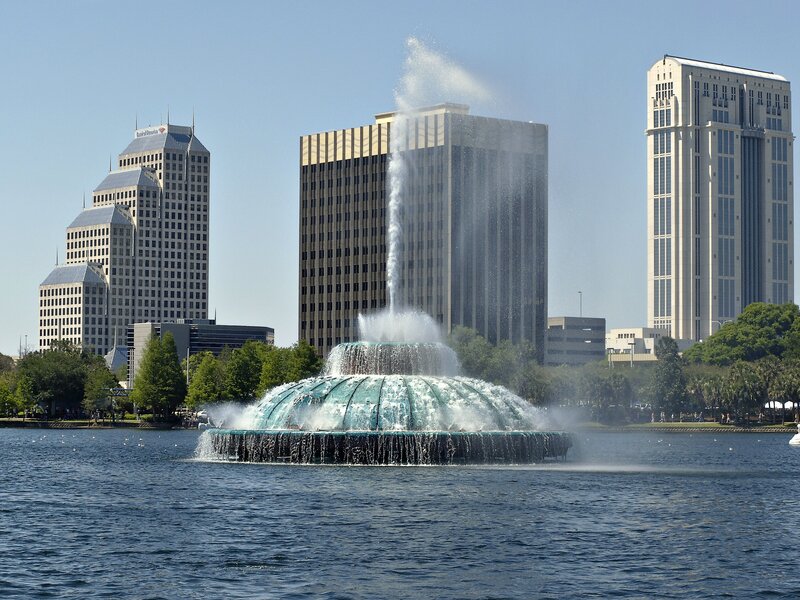 fountain in lake with city skyline