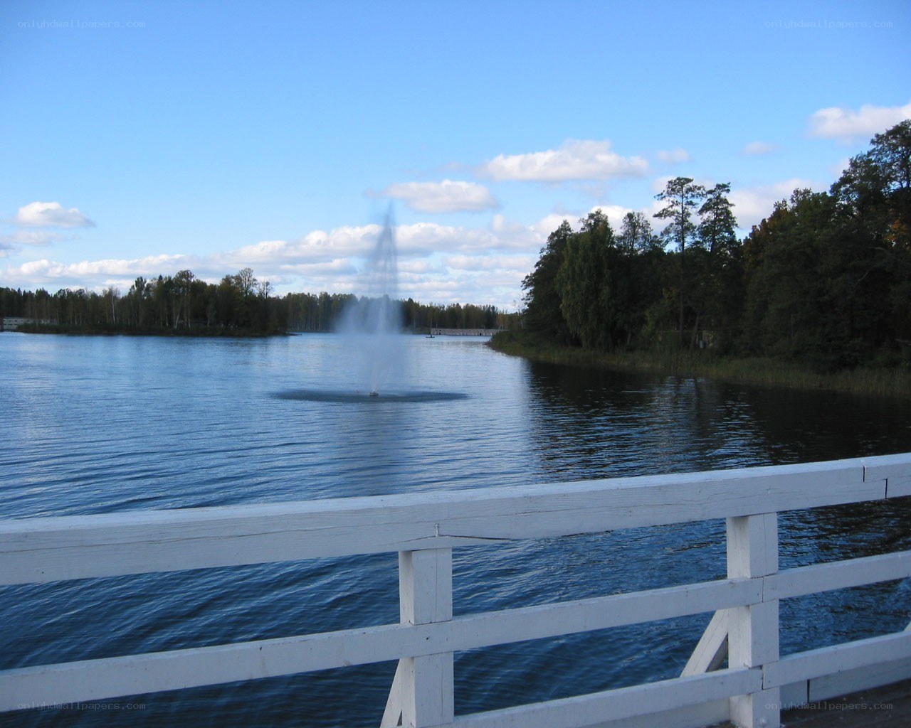 Fountain on a lake with white railing