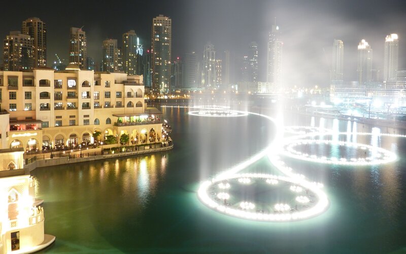 Fountain Show at Night — White, Dramatic, Photograph, Skyscrapers