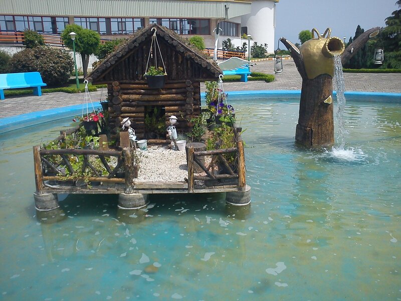 Fountain with log cabin and watering can