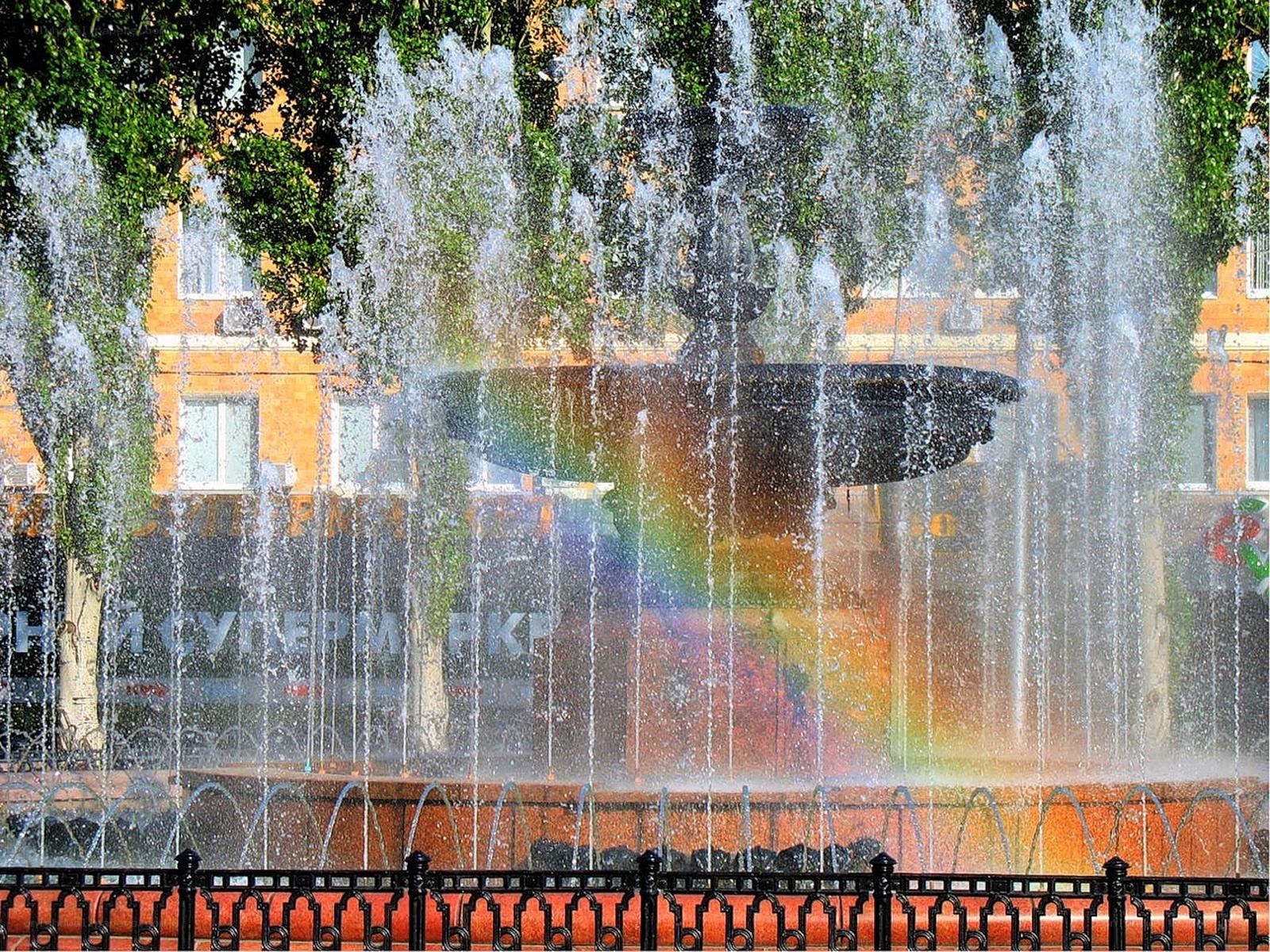 Fountain with rainbow in city