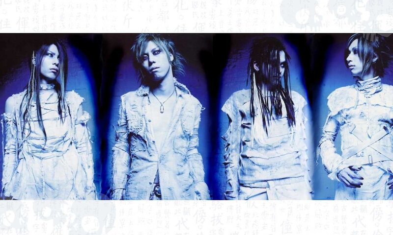 four band members in white outfits