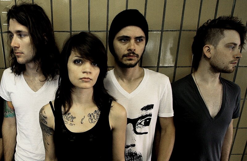 Four Band Members Standing — Black, Serious